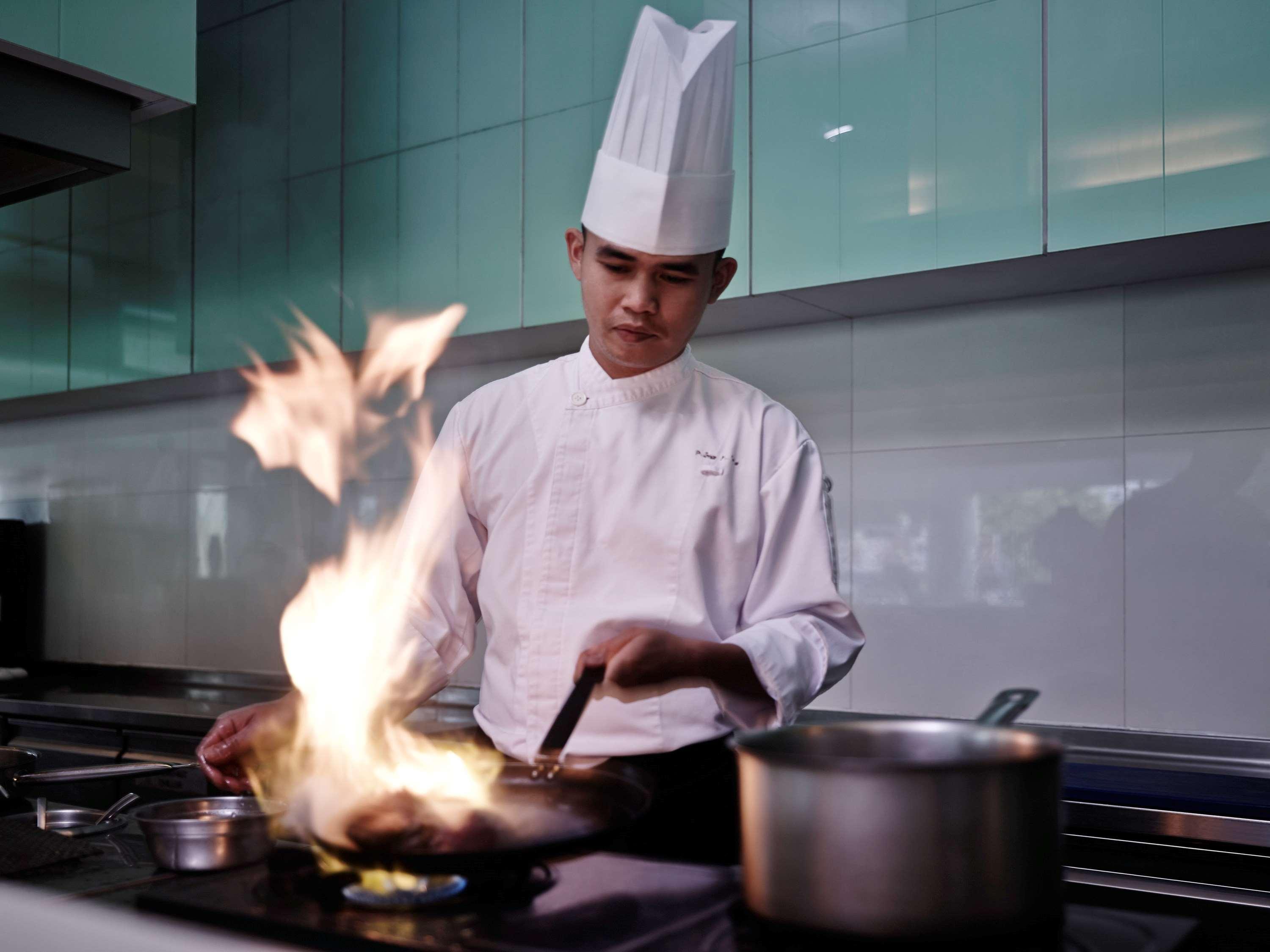 Hotel Pullman Kuching Exteriér fotografie A chef cooking with a flaming wok